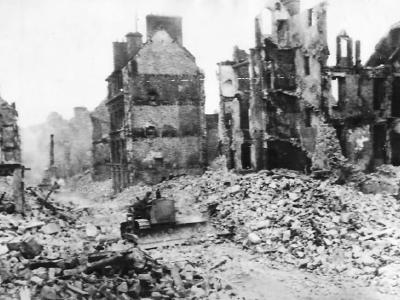 US Army engineers use bulldozer to force a path through street in war shattered Valognes Normady France 1944