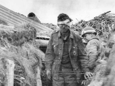 Wounded German Prisoner with MP of 1st ESB 449th MP Co in Normandy