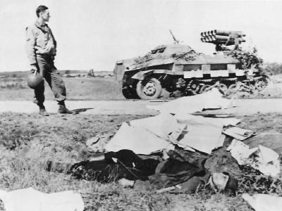 US soldier between Panzerwerfer 42 and fallen German soldier 1944
