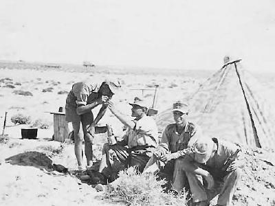 Afrika korps soldiers in desert by camo tent
