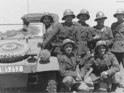 A group of Italian soldiers posing with a Kubelwagen DAK 1941
