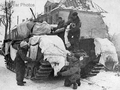 Churchill crew use white bed sheets to help camouflage their tank