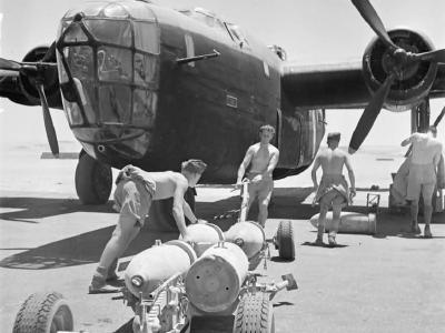 Armourers pull a trolley loaded with 500 lb bombs to a Liberator Mk II of No 159 Squadron RAF at Fayid Egypt