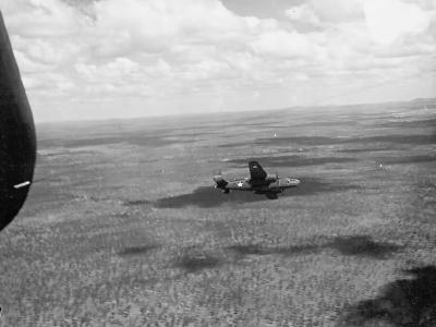 B-25 Mitchell bomber in flight over jungle during World War II