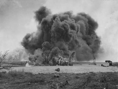 Burning B-29 of 73rd BW following Japanese attack on Isley Field 1944