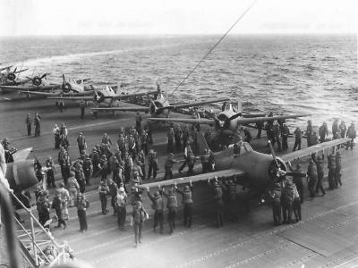 Deck crew pushing a returning F4F into position on the deck of a carrier 1942
