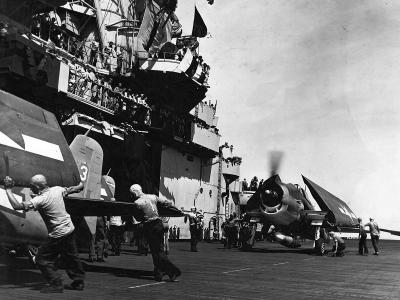 USS Essex CV-9 crew push F6F Hellcats of VF-15 forward 1944