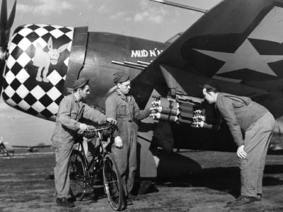 Armorers load fragmentation bombs under the wing of a 353rd Fighter Group P-47 Thunderbolt – 8th AF England 1944