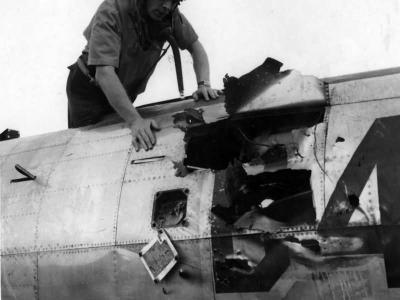 Col Ray J. Stecker of the 365th Fighter Group inspects a flak hole in his P-47 Azeville (A-7) France 1944