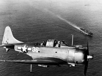 SBD-5 white 36 of the VB-10 over USS Enterprise – March 1944
