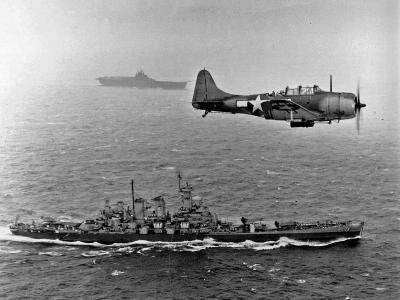 SBD-5 of the VB-16 flies an antisubmarine patrol low over the USS Washington en route to the invasion of the Gilbert Islands on November 12, 1943