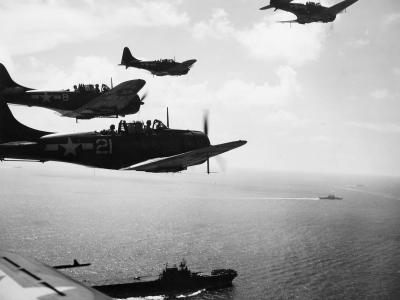SBD-5s of VB-10 pass over USS Enterprise prior to recovery aboard the carrier following strikes against Palau