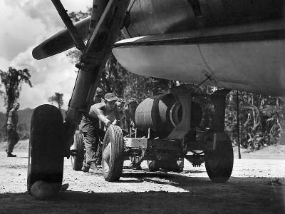 Marine Ordnancemen load 2000 lb bomb into the bomb bay of a Grumman TBF Avenger, 1944