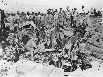Marines watch as Navy Corpsmen remove the dead and wounded from the pit