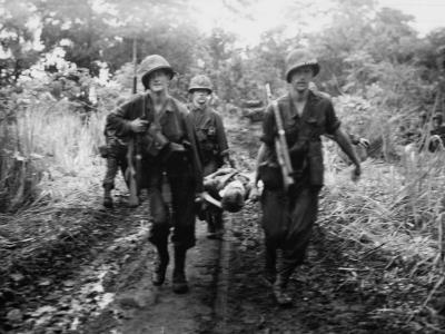 Marines carry wounded comrade for aid on Cape Gloucester