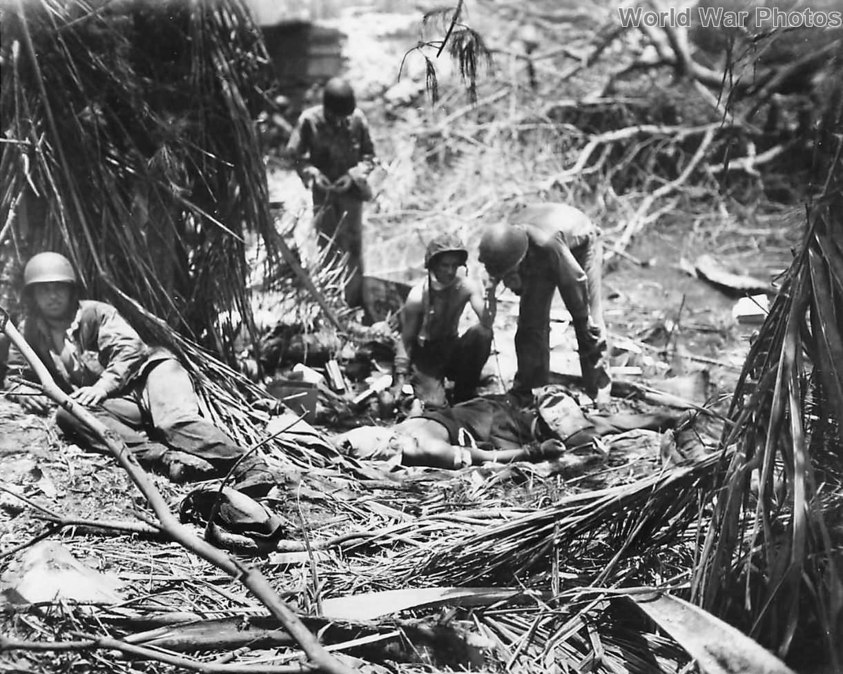 Hospital corpsmen give plasma to wounded Marine on Guam
