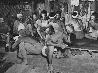 Japanese soldiers laugh as fellow prisoners play game on Guam 1945