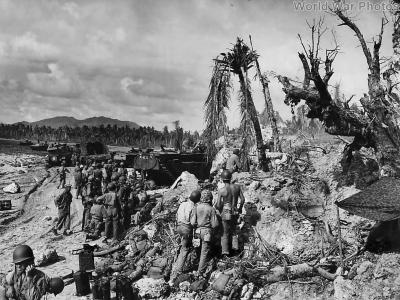 Troops and vehicles landing on shell torn beach on Guam