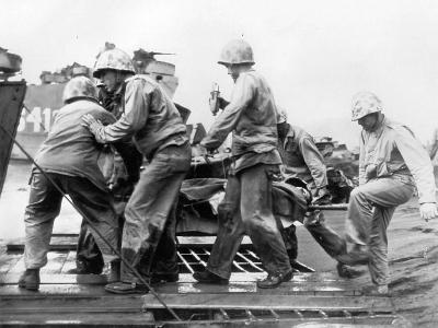 Wounded Marine gets transfusion loaded on LST