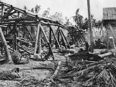 US Troops move thru ruins of Japanese warehouse on Makin