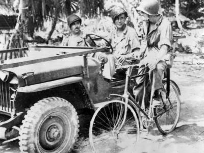 Soldiers in Jeep and on bicycle on newly captured Makin Atoll