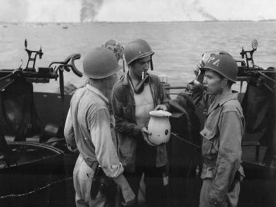 Smoke Rises from Peleliu as Gun Crew on LCI Breaks for Coffee