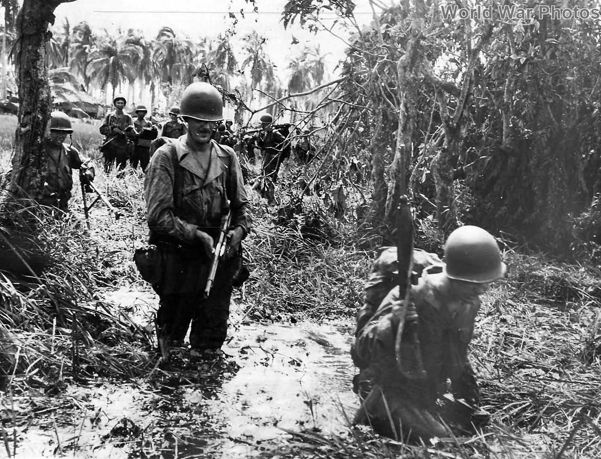 1st Cavalry troops advance thru waist deep mire on Leyte