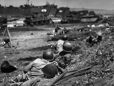 Coast Guardsmen shelter from Japanese fire on Luzon Beach