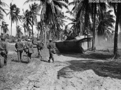 Soldiers advancing under cover of Amtrac on Luzon 1945