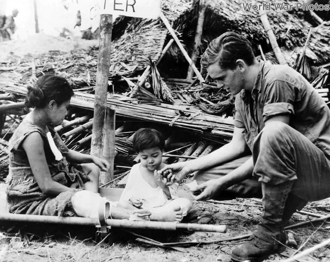 US Soldier gives child candy at Navy Evacuation Center on Leyte 1944