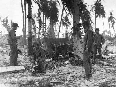 Coast Guardsmen inspect Japanese field gun on Tarawa