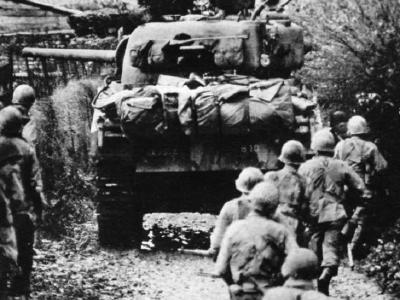 Troops advance under cover of a Sherman tank, Metz September 1944