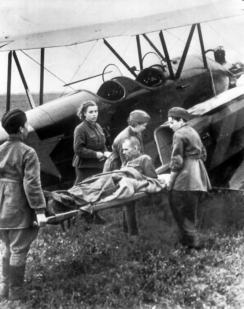 Wounded Russian soldier being loaded onto a Polikarpov U-2 / Po-2 ambulance plane by nurses