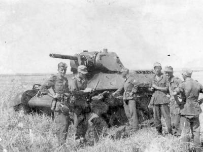 Wehrmacht soldiers next to a tank T-34 model 1941